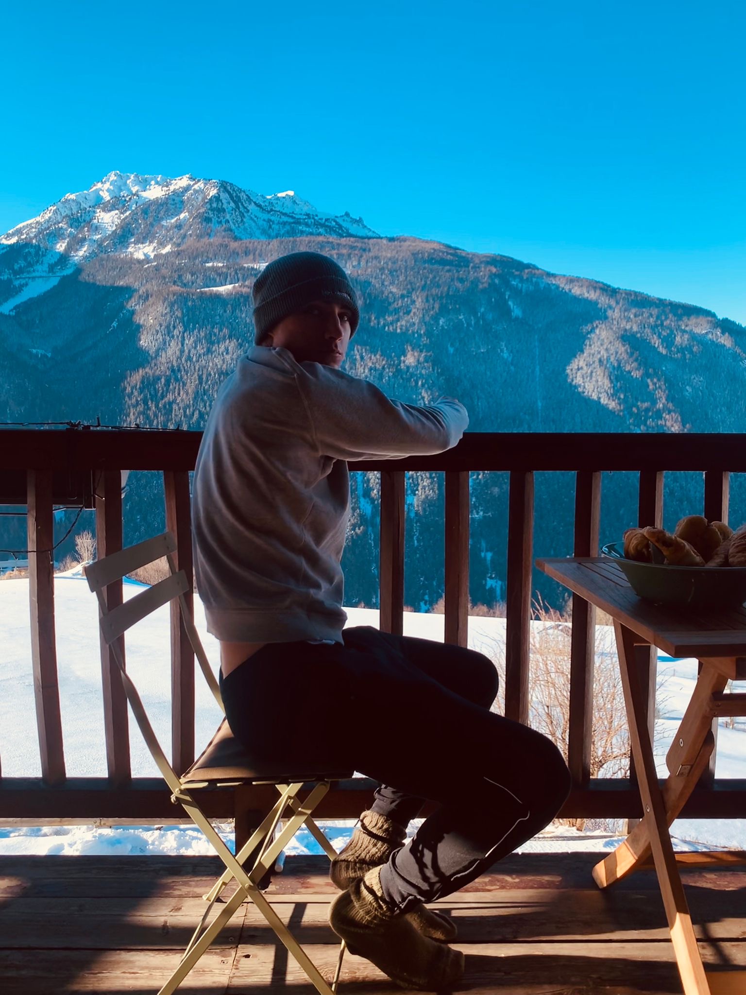 Angelo sitting with a mountain view behind him