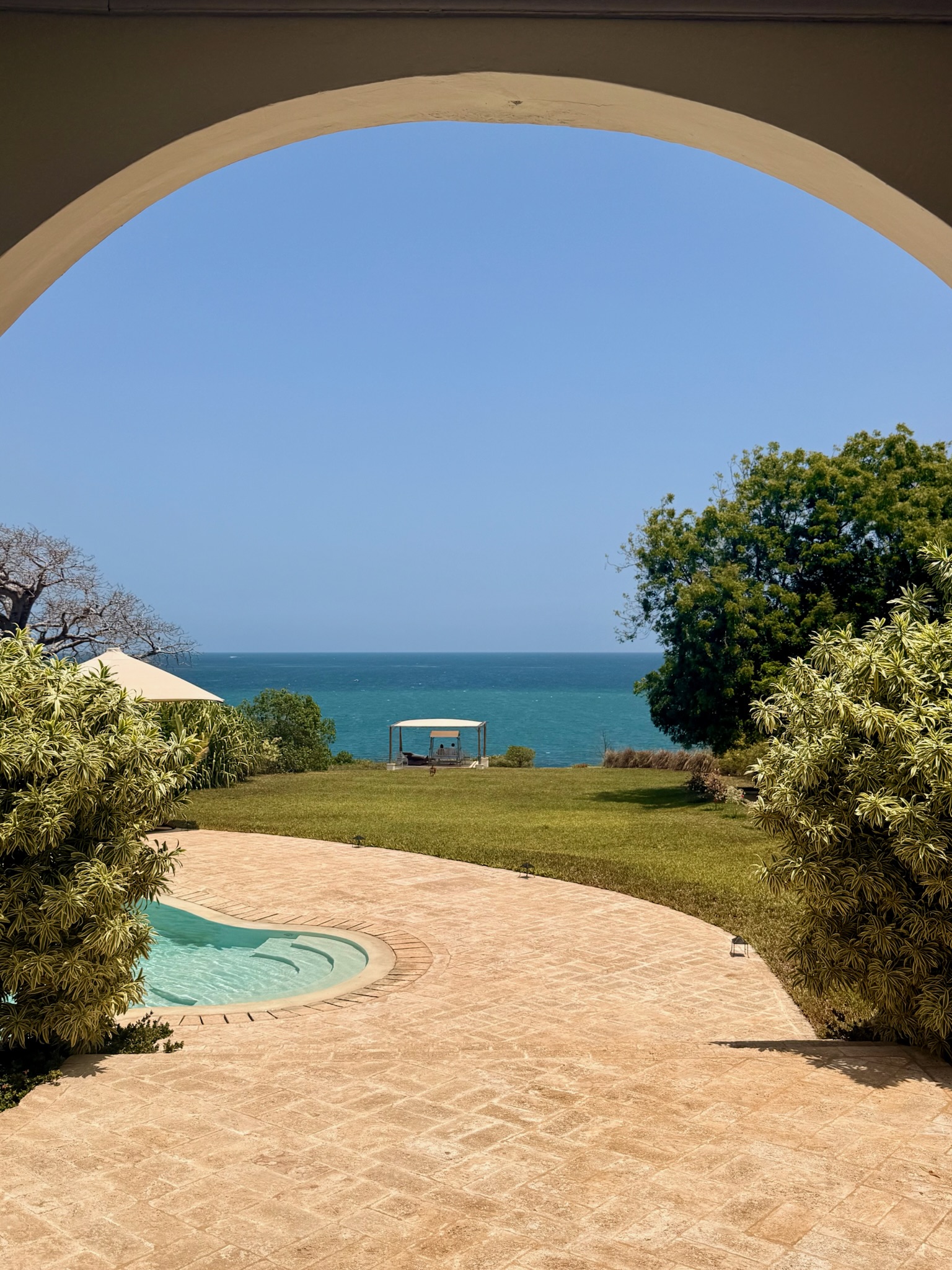 Ocean view framed by an archway and pool edge