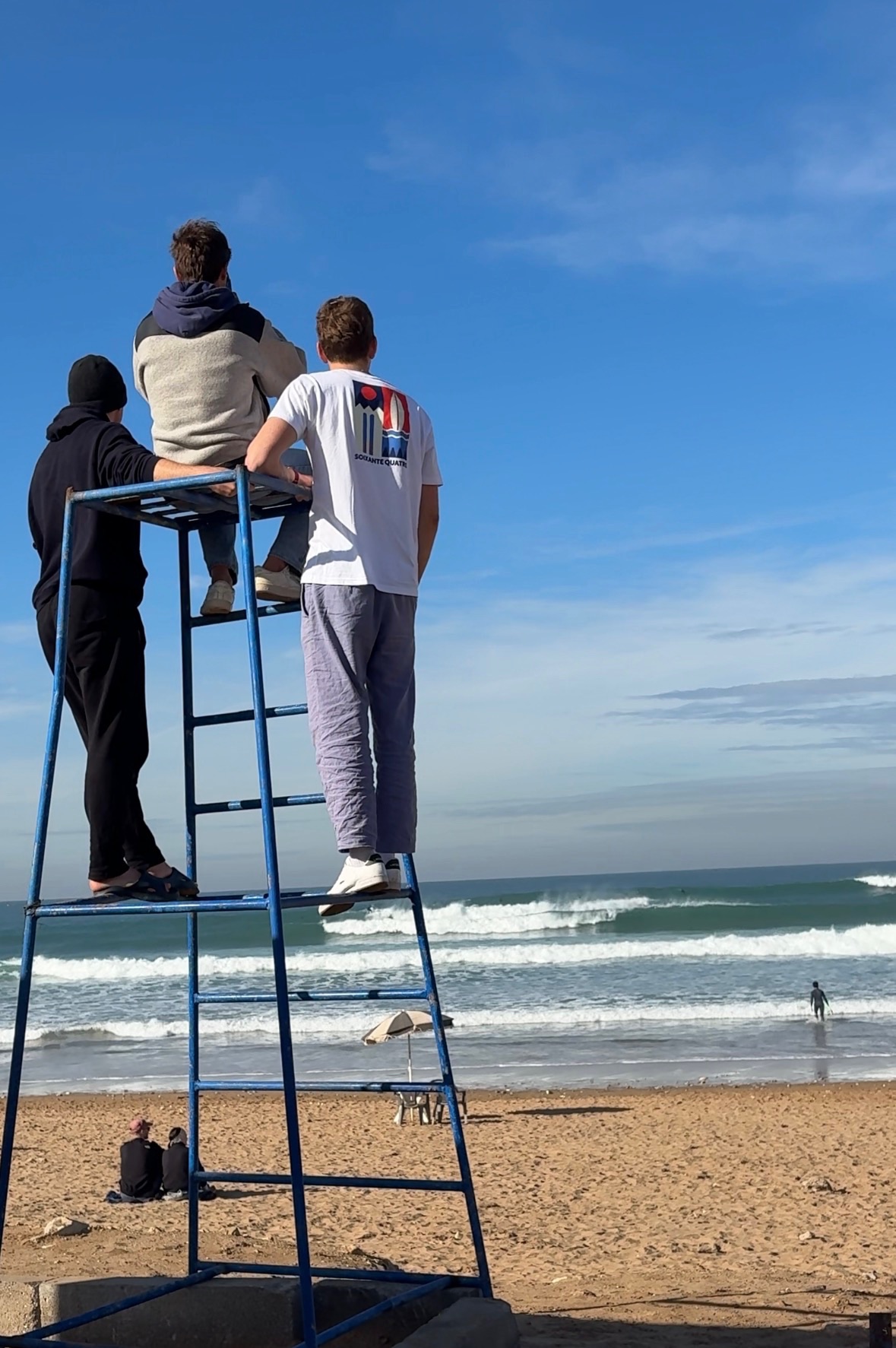 Angelo and friends scouting waves from a lifeguard chair in Morocco